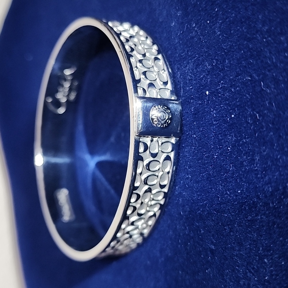 COACH Silver Bangle Bracelet with Signature Classic “C” Logo Print.